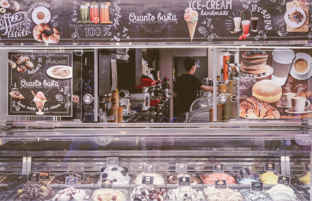 A vibrant ice cream stall featuring an array of flavors, toppings, and a coffee bar.